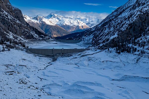 Přehrada Avio a spoře zasněžené jižní svahy v národním parku Stelvio